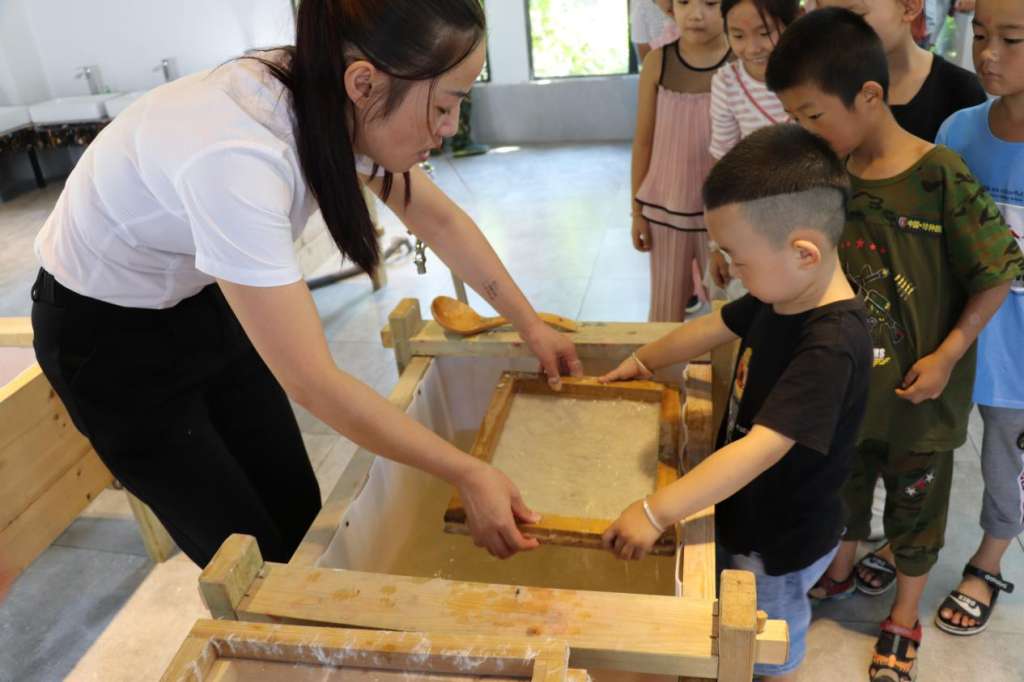 孩子们在四大发明文化馆体验中华传统文化——造纸术.